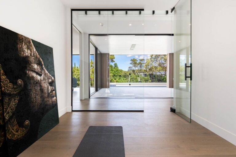 Oak timber flooring running through a contemporary hallway to a glazed doorway, where the floor changes to a hard tiled surface.