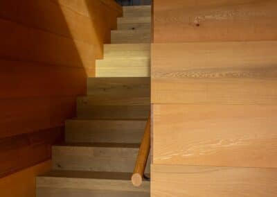 View of the staircase area in the Waiheke Island project featuring Manhattan oak timber flooring and wood accents.