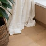 Close up of Bordeaux European oak timber flooring with linen curtains in Auckland home