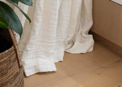 Close up of Bordeaux European oak timber flooring with linen curtains in Auckland home