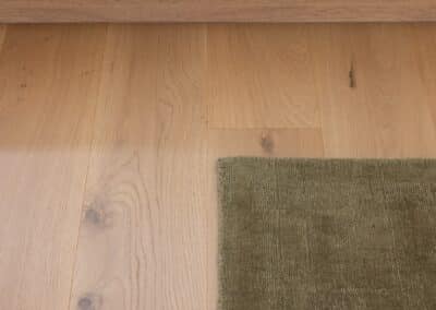 Close up of Bordeaux European oak timber flooring with green rug in Auckland home