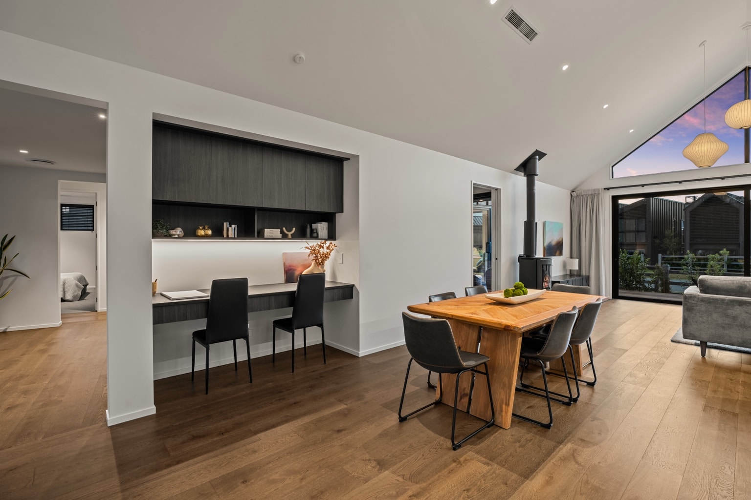 Wide plank European oak flooring in a dining area with timber table and built in home office niche in a Queenstown New Zealand home
