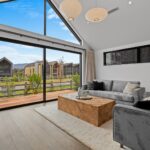 Wide plank European oak flooring in a modern open plan living room and kitchen with large sliding doors and mountain view in Queenstown New Zealand