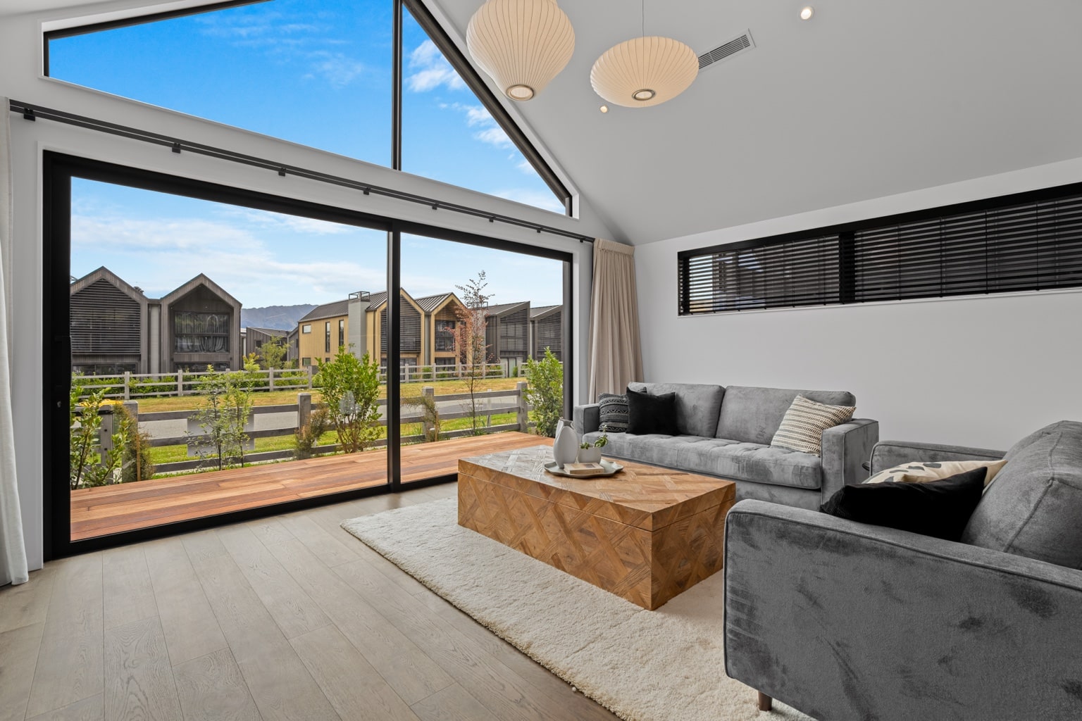 Wide plank European oak flooring in a modern open plan living room and kitchen with large sliding doors and mountain view in Queenstown New Zealand