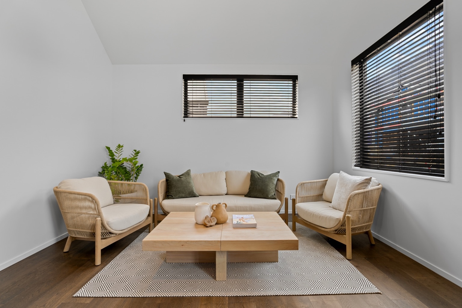Wide plank European oak flooring in a secondary living room with lounge seating, timber coffee table and window blinds in a Queenstown New Zealand home
