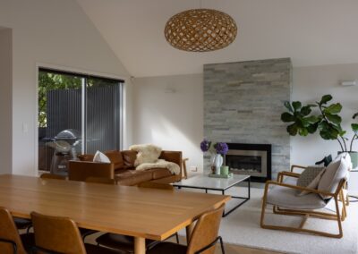 Dining and living area with fireplace over Bordeaux herringbone oak flooring in Westmere home