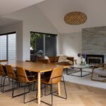 Dining room with fireplace over Bordeaux herringbone oak flooring in Westmere home