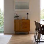 Dining area with timber sideboard over Bordeaux herringbone oak flooring in Westmere home