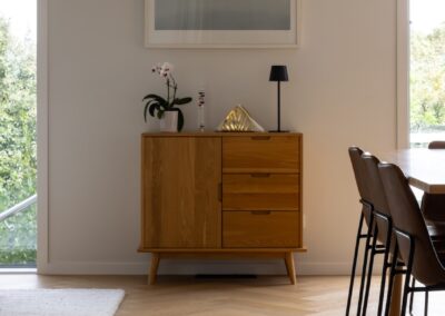 Dining area with timber sideboard over Bordeaux herringbone oak flooring in Westmere home