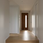 Entry hallway with front door and Bordeaux herringbone oak flooring in Westmere home
