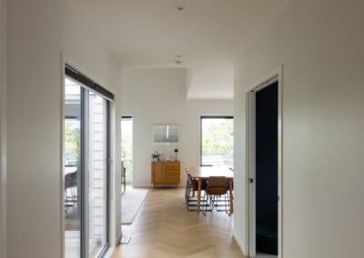 Hallway leading to dining area over Bordeaux herringbone oak flooring in Westmere home