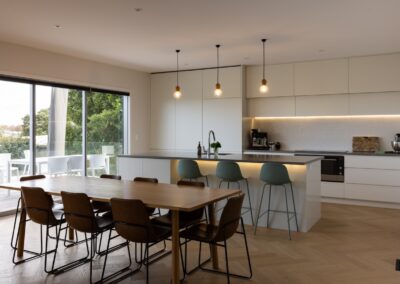 Wide view of kitchen and dining area with Bordeaux herringbone oak flooring in Westmere home