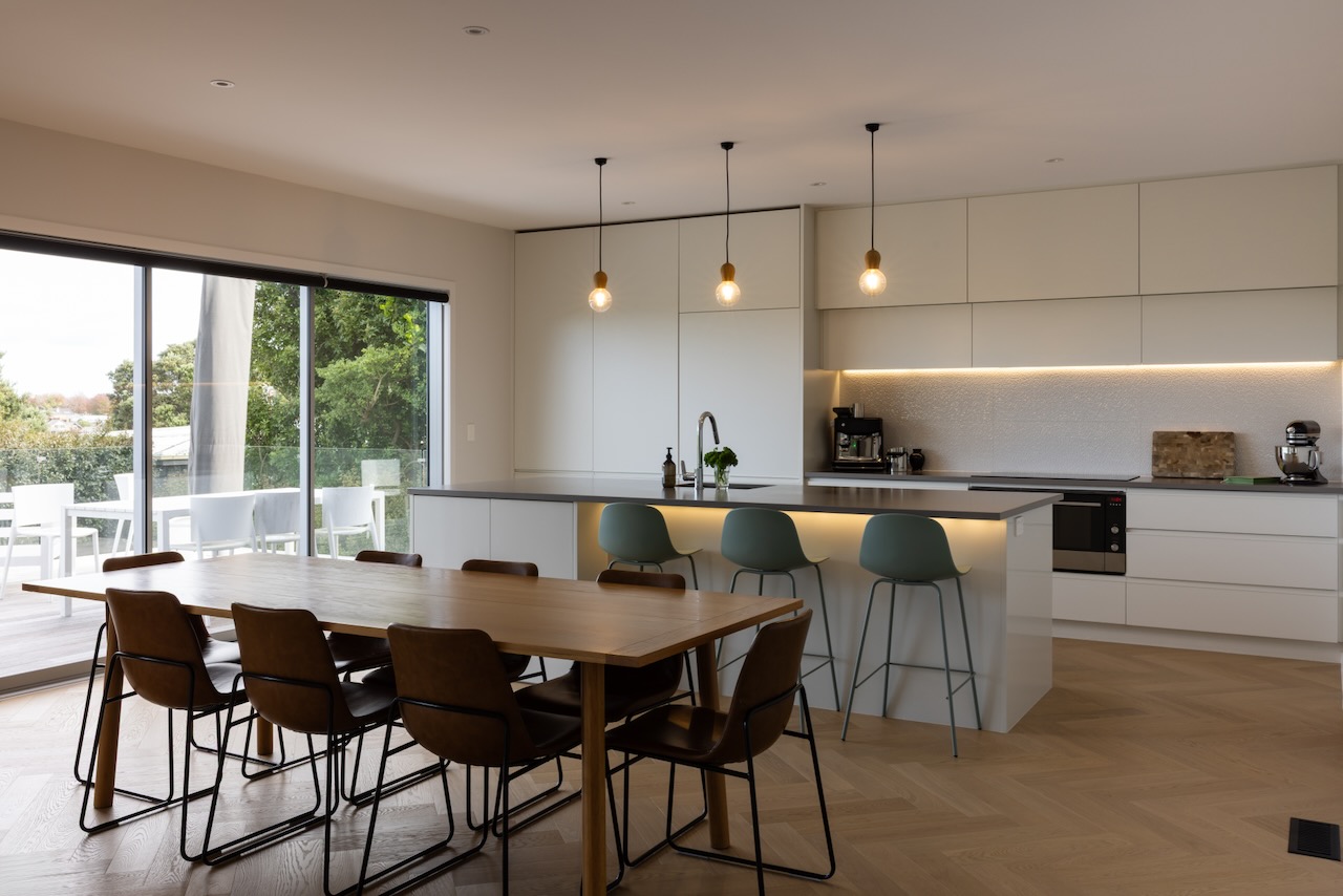 Wide view of kitchen and dining area with Bordeaux herringbone oak flooring in Westmere home