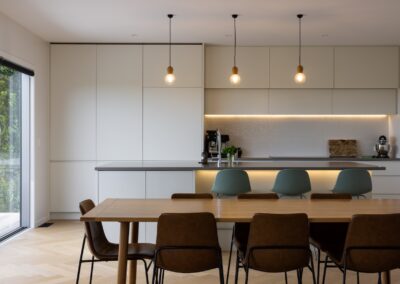 Wide view of kitchen and dining area with Bordeaux herringbone oak flooring in Westmere home