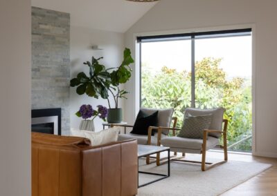 Living room with leather sofa over Bordeaux herringbone oak flooring in Westmere home