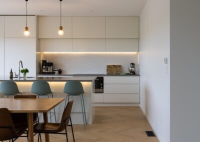 Open plan kitchen and living area with Bordeaux herringbone oak flooring in Westmere home