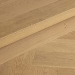 Bordeaux oak herringbone flooring meeting timber stair step detail in Westmere home