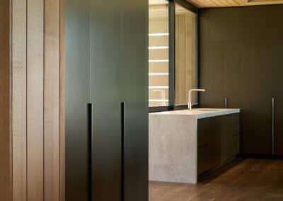 Dark engineered oak timber flooring in modern kitchen with timber ceiling lining and minimalist cabinetry