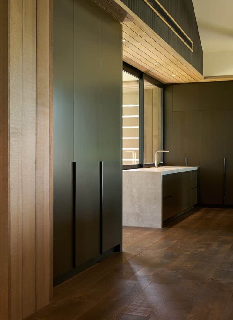 Dark engineered oak timber flooring in modern kitchen with timber ceiling lining and minimalist cabinetry