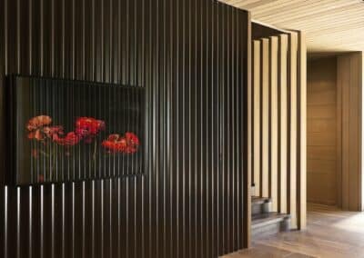 Dark engineered oak timber flooring with vertical black wall battens and timber ceiling detail in modern interior