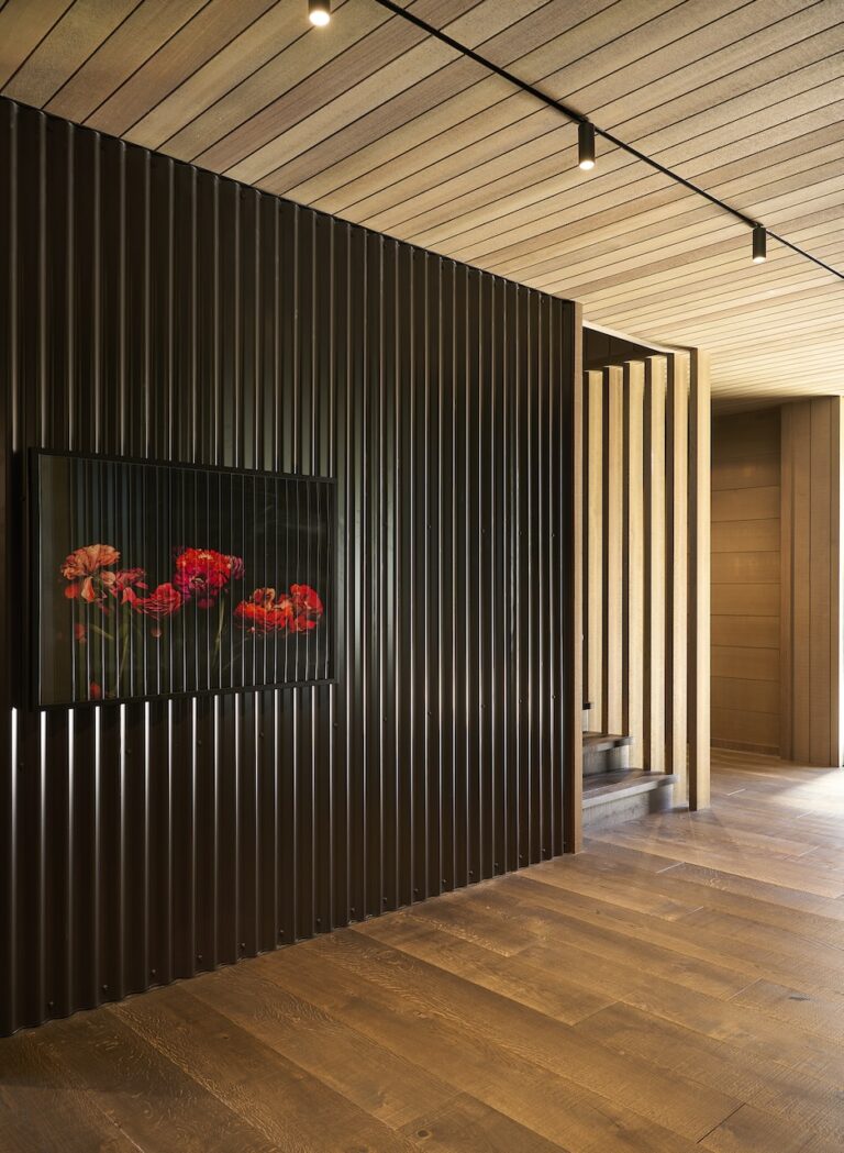 Dark engineered oak timber flooring with vertical black wall battens and timber ceiling detail in modern interior