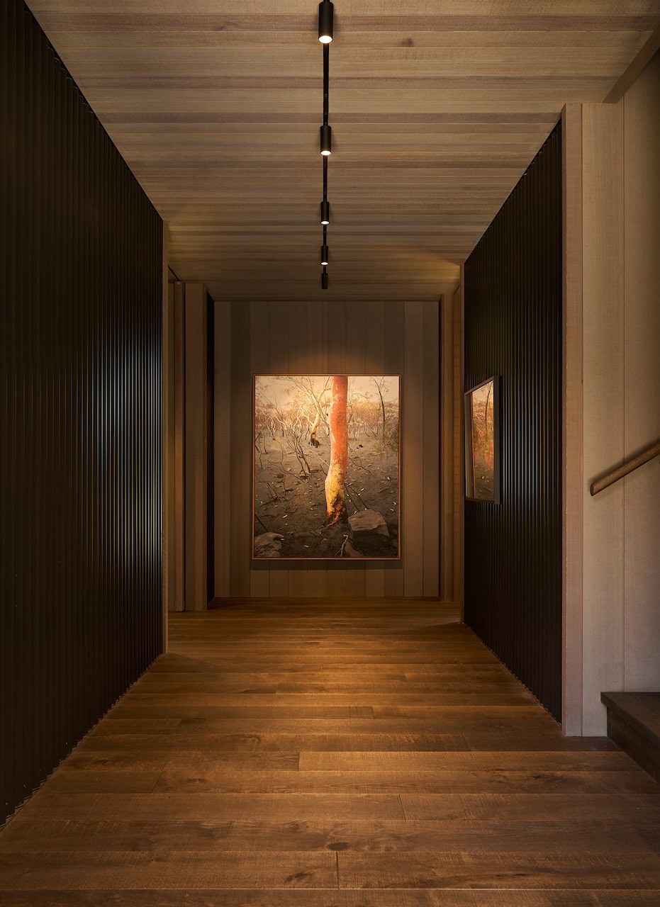 Dark engineered oak timber flooring in architectural hallway with timber ceiling lining and vertical wall battens