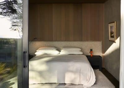 Dark engineered oak timber flooring in modern bedroom with indoor outdoor connection and sliding glass door
