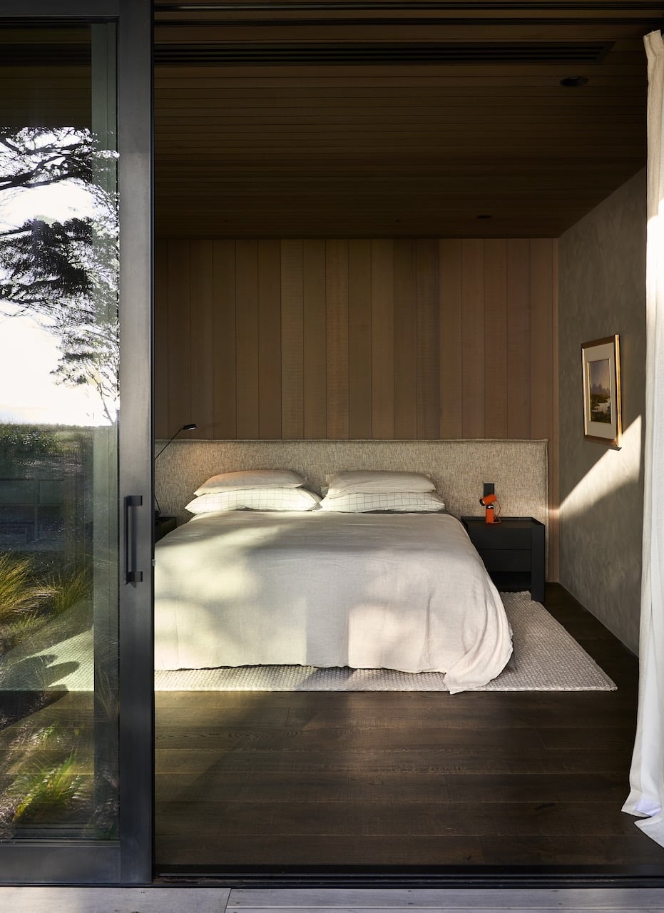 Dark engineered oak timber flooring in modern bedroom with indoor outdoor connection and sliding glass door