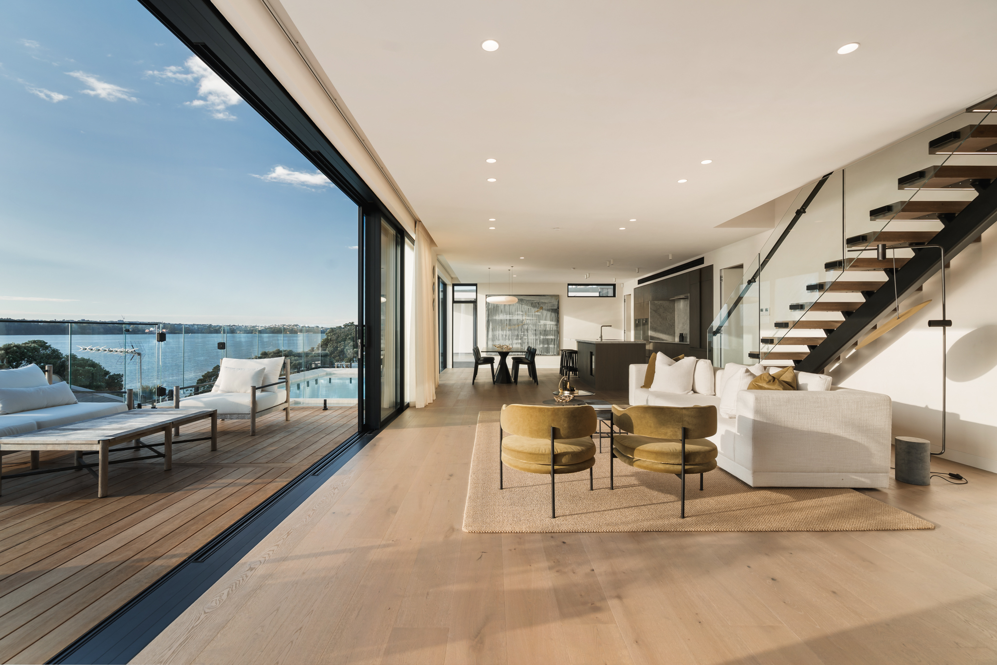 Westwood engineered oak flooring with sliding doors opened to harbour deck, Westmere Auckland.