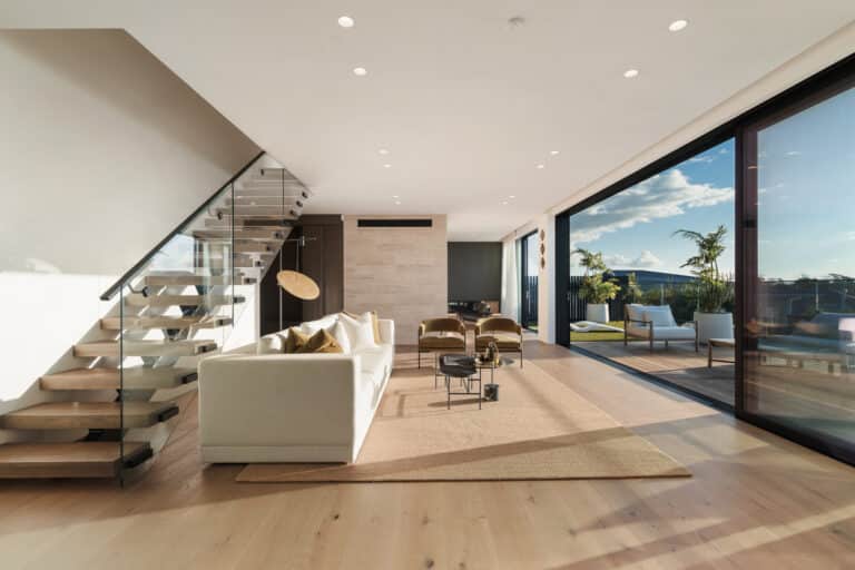 Westwood engineered oak flooring in living room with floating stairs and harbour view, Westmere.