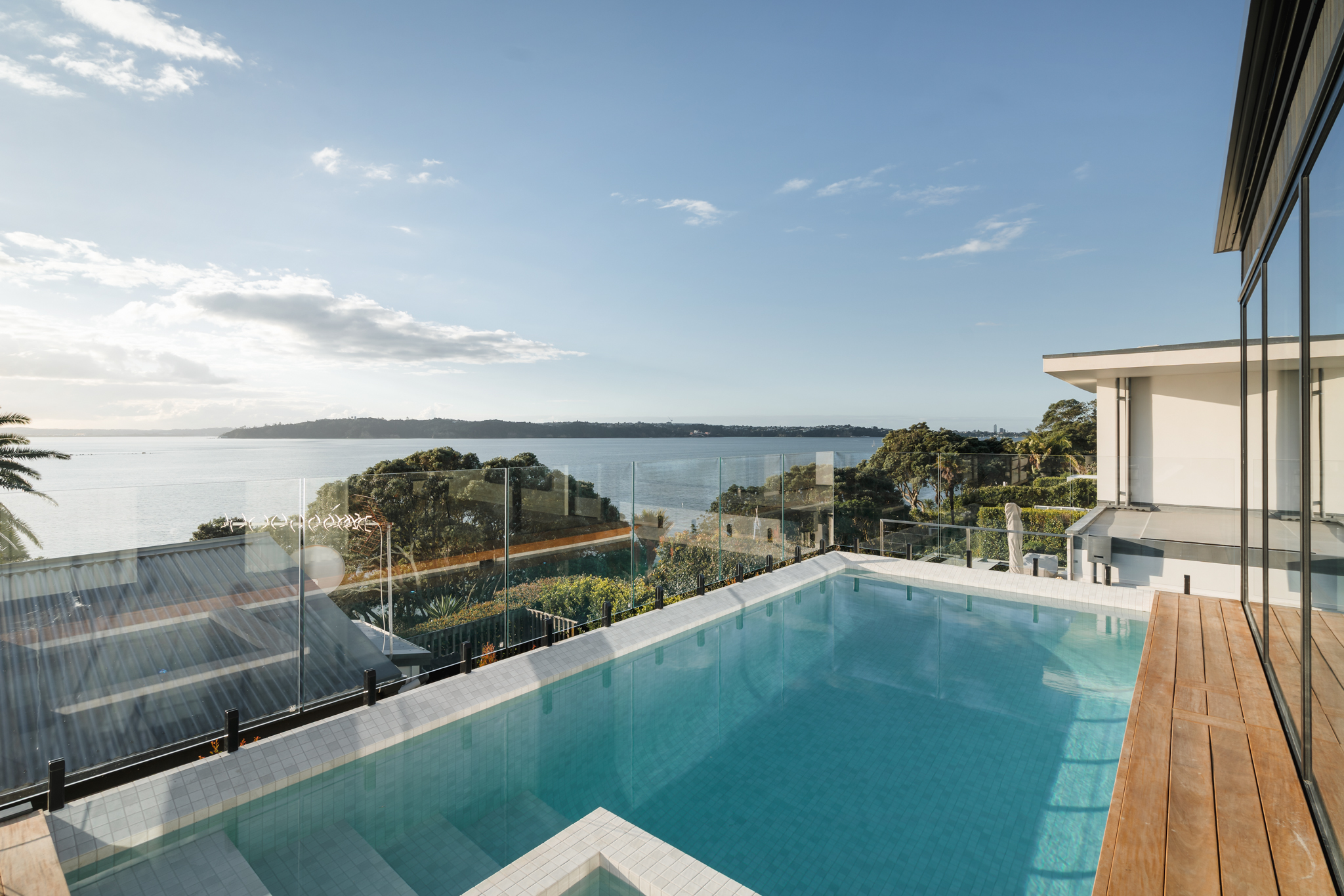 Infinity-edge pool spilling toward harbour view, Westmere Auckland.