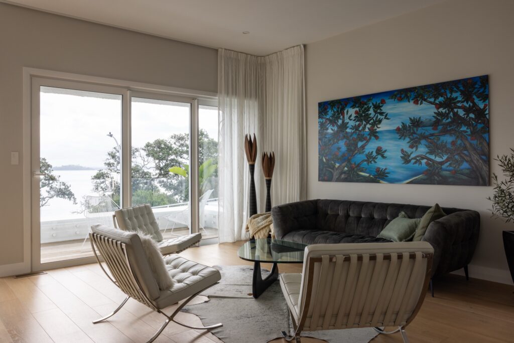 Sazerac European oak flooring in 220mm wide planks running through a light-filled clifftop living room with sea views in Saint Heliers, Auckland.