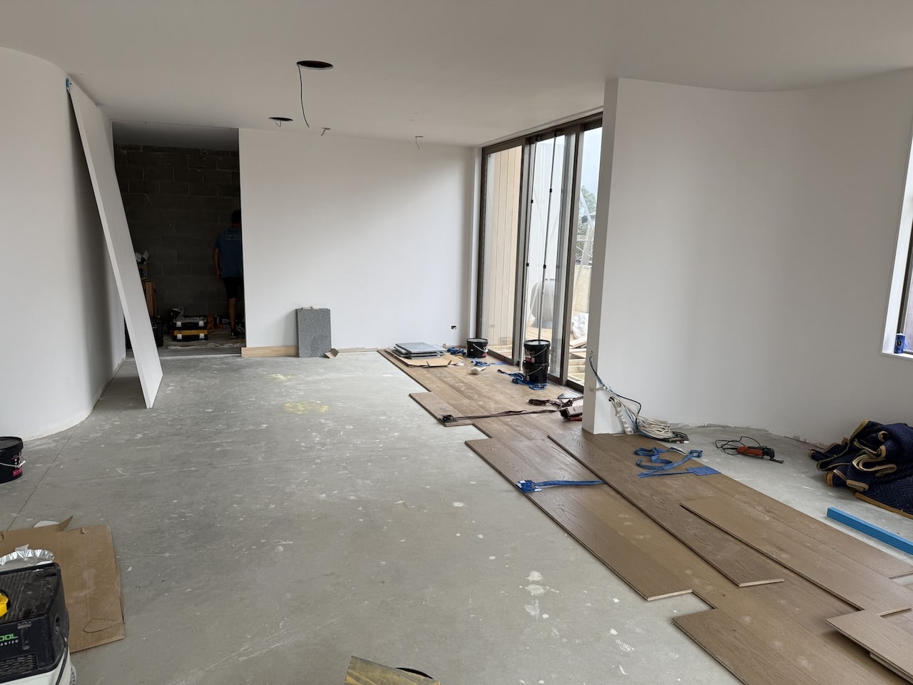 Engineered European oak boards being laid over adhesive during a glue-down installation