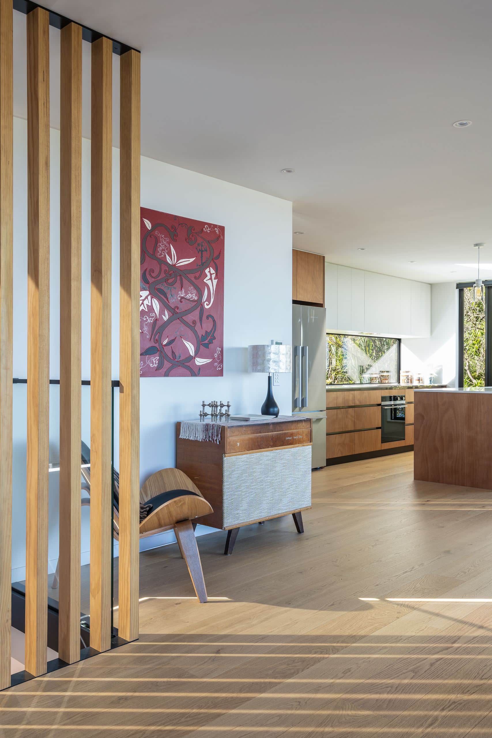 Foundation Pureline oak flooring past a vertical timber screen at the entry of a Hillsborough home.