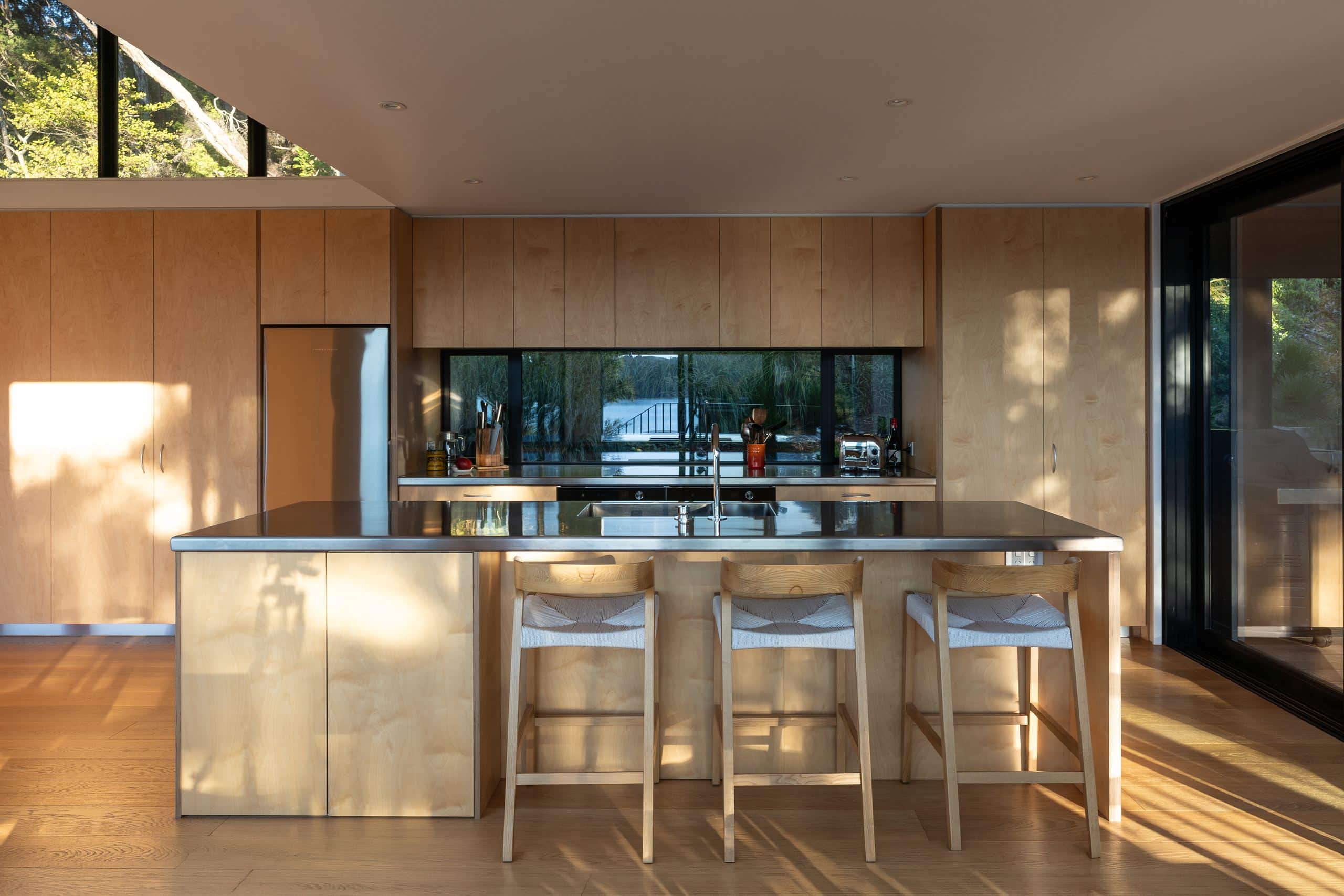 Foundation Pureline oak flooring beneath a plywood kitchen with a stainless steel benchtop, Waiheke Island.