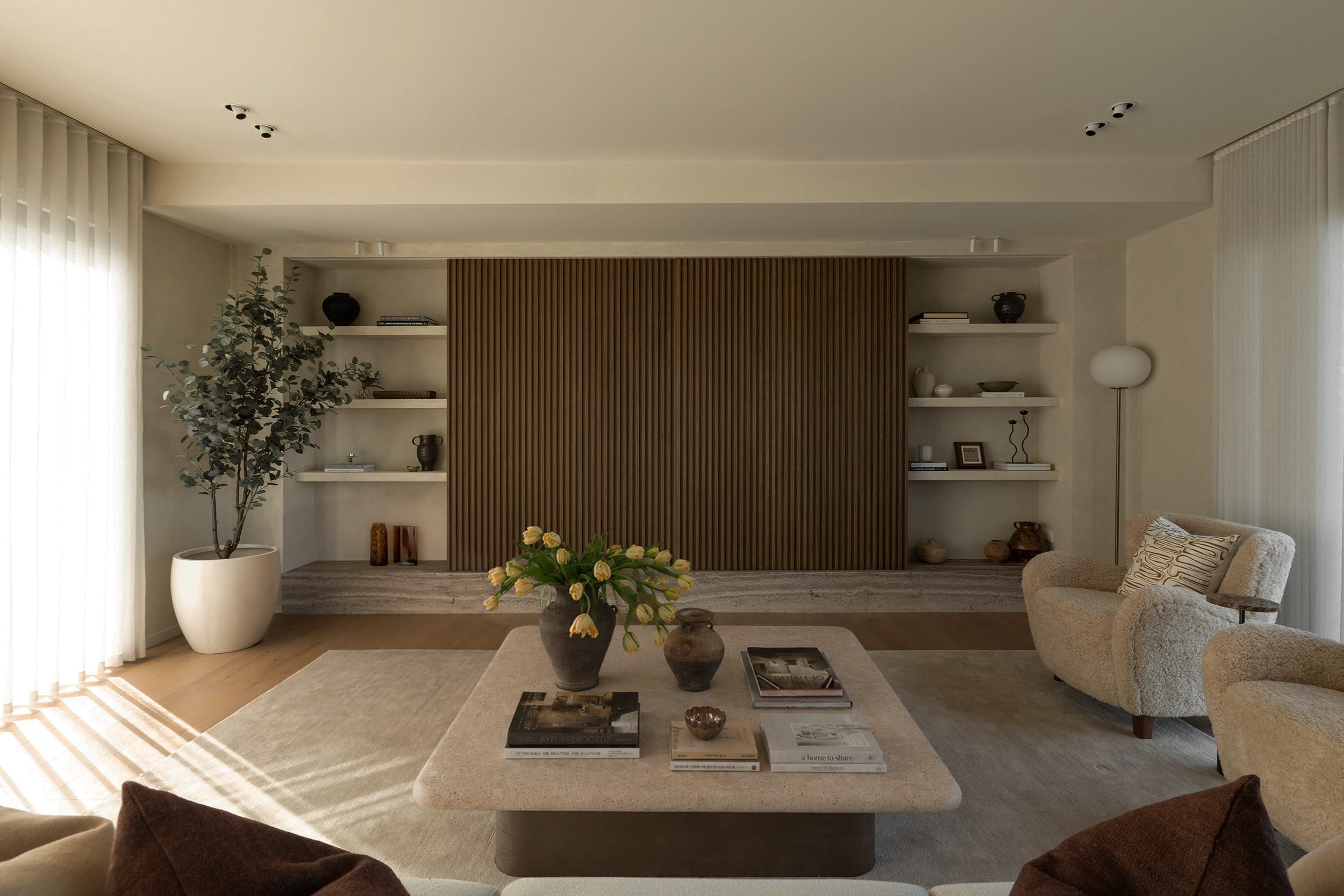 Icons Conde oak flooring in a Hobsonville living room, with a fluted timber wall panel set between plaster shelving niches.